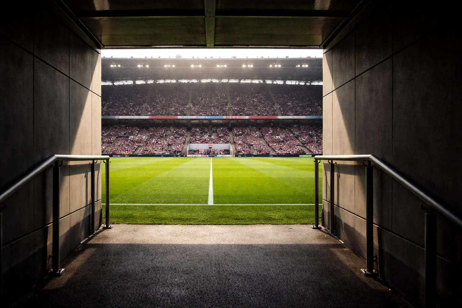 Estadio de la Premier League lleno de aficionados durante un partido nocturno